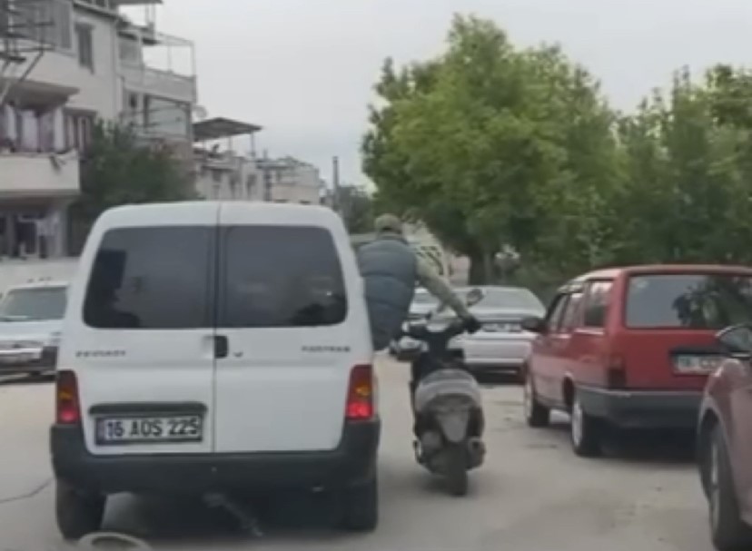 Motosikleti seyir halindeki aracın camından sarkarak götürdü